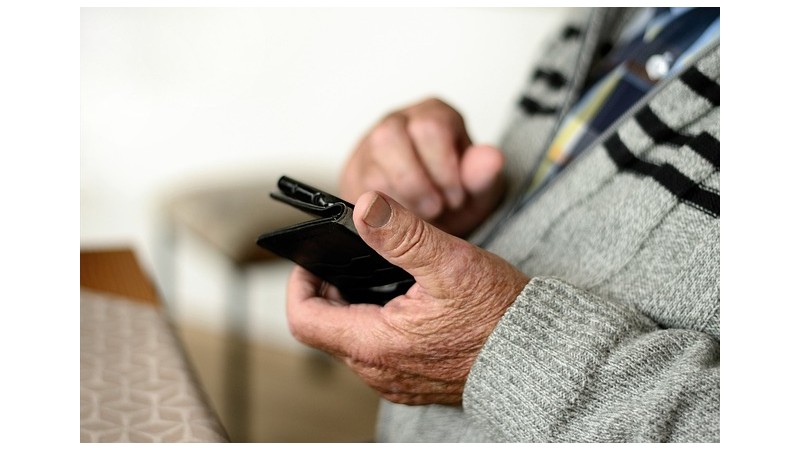 Mężczyzna w wieku senioralnym z telefonem w dłoni, fot. pixabay